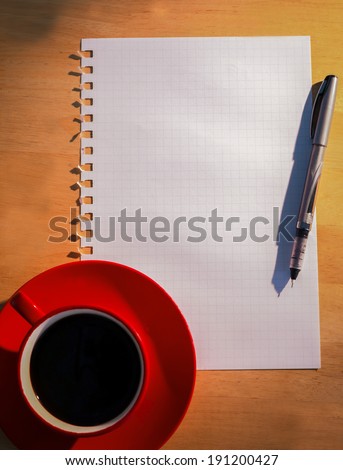 Overhead of graph paper coffee and pen on a desk