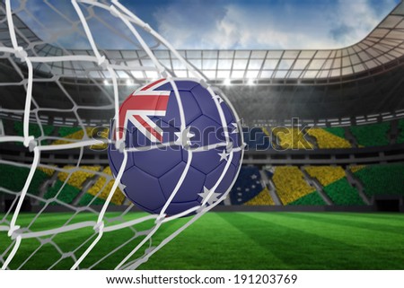 Football in australia colours at back of net against large football stadium with brasilian fans