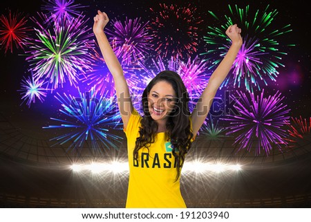 Excited football fan in brasil tshirt against fireworks exploding over football stadium