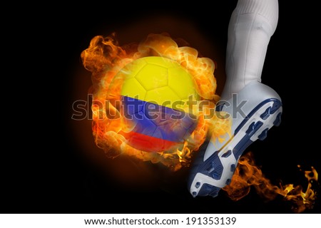 Football player kicking flaming colombia ball against black