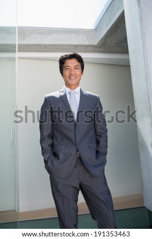 Confident estate agent standing at front door outside a house