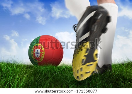 Composite image of football boot kicking portugal ball against field of grass under blue sky