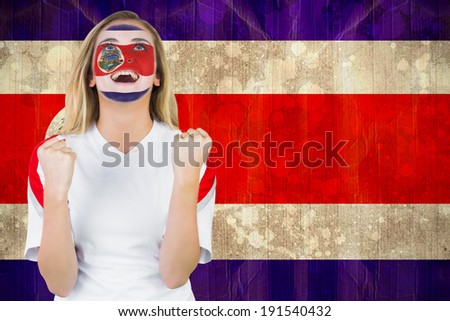 Excited costa rica fan in face paint cheering against costa rica flag in grunge effect