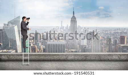 Businessman standing on ladder against balcony overlooking city