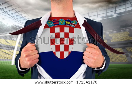 Businessman opening shirt to reveal croatia flag against large football stadium with lights