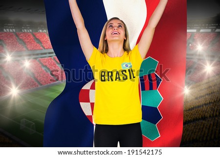 Excited football fan in brasil tshirt holding croatia flag against vast football stadium with fans in yellow and red