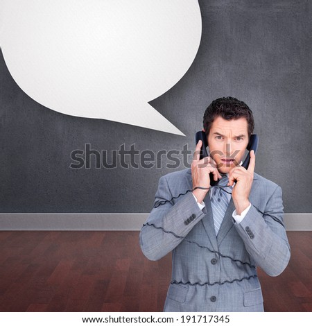 Angry businessman tangle up in phone wires against speech bubble