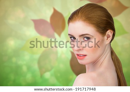 Beautiful redhead looking at camera against leaf pattern in green and brown