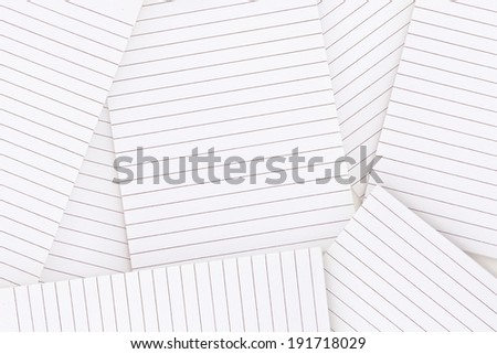 Lined notepad paper strewn over surface