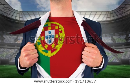 Businessman opening shirt to reveal portugal flag against large football stadium under spotlights