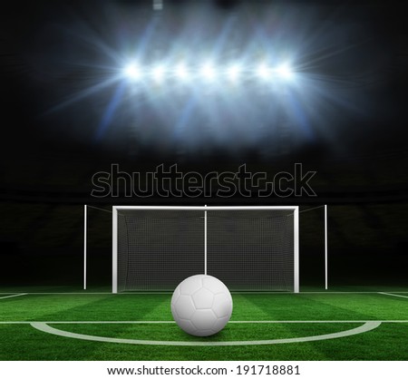 Digitally generated white leather football against football pitch under spotlights