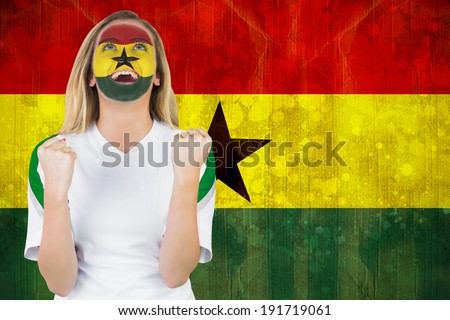 Excited ghana fan in face paint cheering against ghana flag in grunge effect