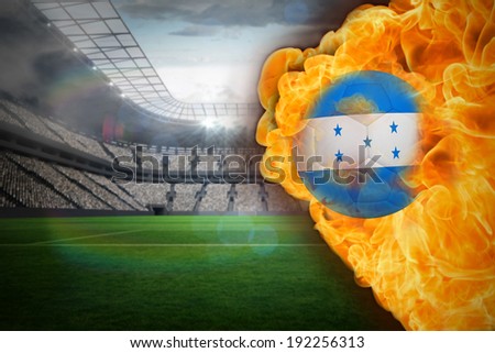 Composite image of fire surrounding honduras flag football against large football stadium with lights