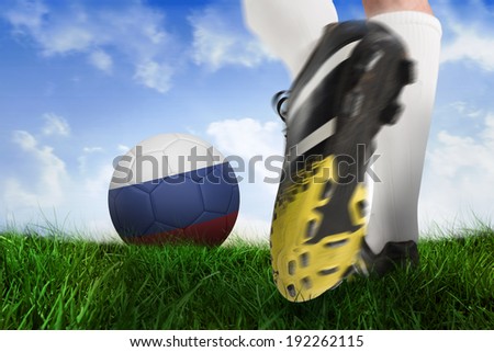 Composite image of football boot kicking russia ball against field of grass under blue sky