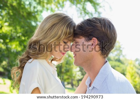 Cute couple facing each other in the park on a sunny day
