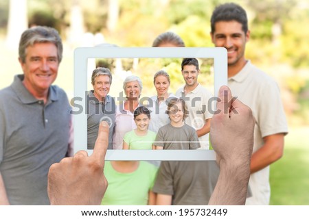 Hand holding tablet pc showing family in the park