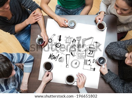 People sitting around table drinking coffee with page showing brainstorm graphic