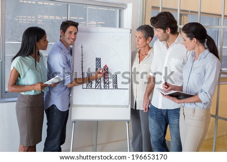 Businessman explaining graph to coworkers in the office