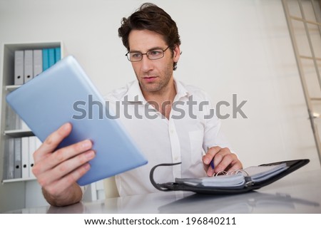 Casual businessman organizing his schedule at his desk in his office