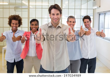 Management smiling and giving thumbs up to camera in the office