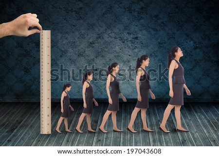 Composite image of hand measuring businesswoman with ruler against dark grimy room