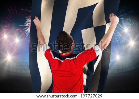 Excited football fan cheering against fireworks exploding over football stadium and greece flag