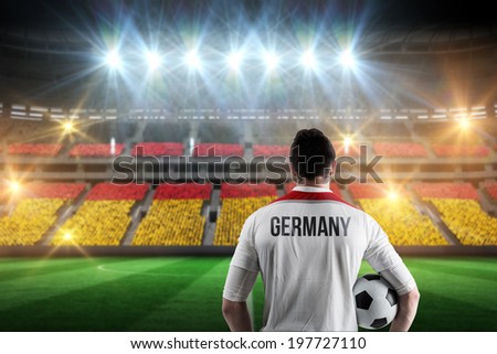 Germany football player holding ball against stadium full of germany football fans