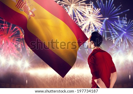Football player in red jersey against fireworks exploding over football stadium