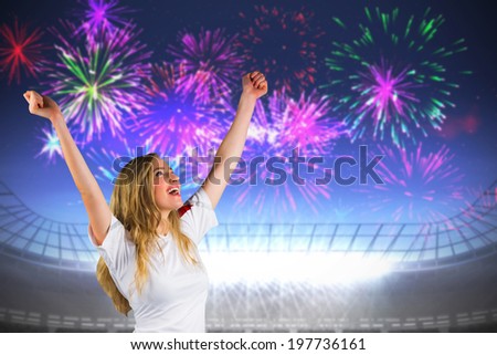 Pretty football fan in white cheering against fireworks exploding over football stadium