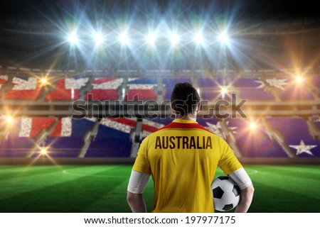 Australia football player holding ball against stadium full of australia football fans