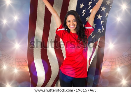 Cheering football fan in red holding usa flag against large football stadium under purple sky