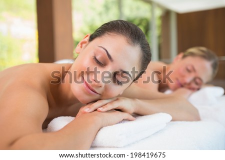 Peaceful friends lying on massage tables in the health spa