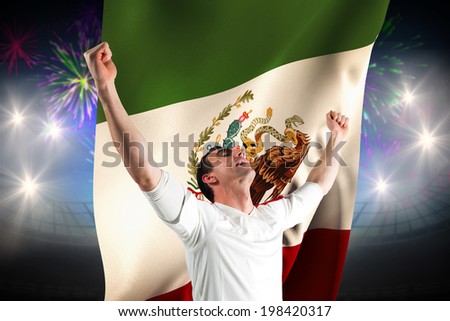 Excited football fan cheering against fireworks exploding over football stadium and mexico flag