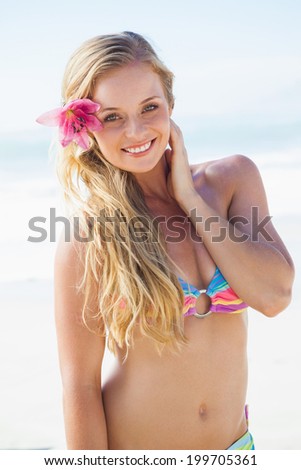 Gorgeous blonde in bikini smiling at camera on a sunny day