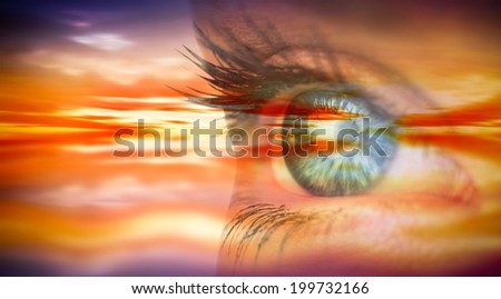 Close up of female blue eye against purple sky with orange clouds