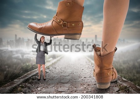 Composite image of cowboy boots stepping on businesswoman against stony path leading to large city on the horizon