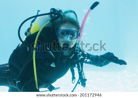 Woman on scuba training submerged in swimming pool on her holidays