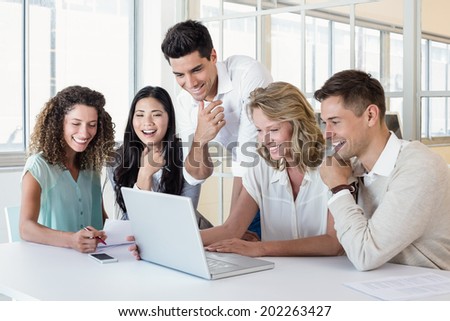 Casual business team having a meeting using laptop in the office