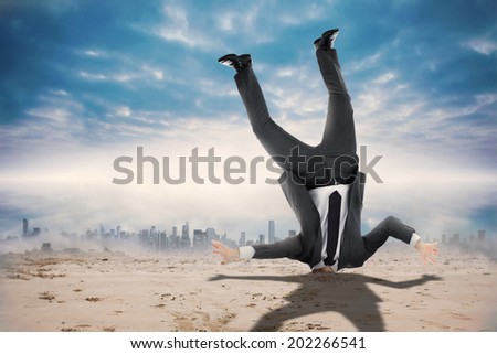 Businessman burying his head against dusty path leading to city under the clouds