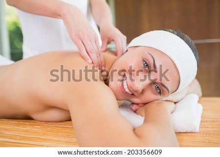 Smiling woman getting a back massage in the health spa