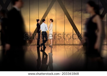 Business colleagues talking against room with large window looking on city