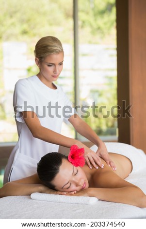 Brunette enjoying a peaceful massage at the health spa