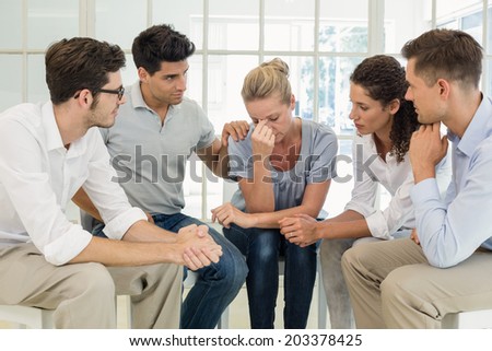 Group therapy in session sitting in a circle in a bright room