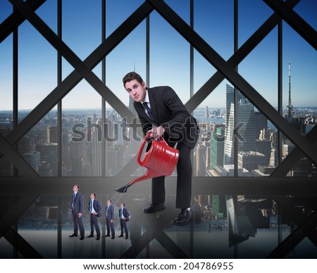 Businessman watering tiny businessman against room with large window looking on city