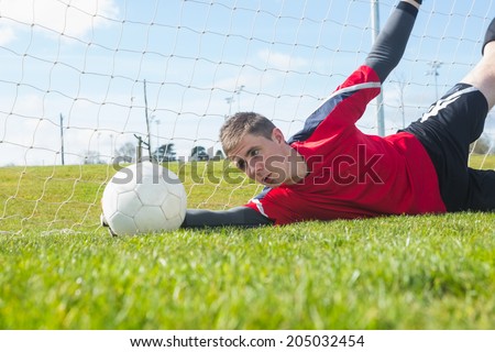 Goalkeeper in red making a save during a match
