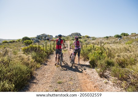 Active couple cycling in the countryside looking to the side on a sunny day