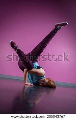 Pretty break dancer busting a move in the dance studio