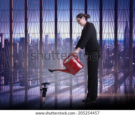 Businesswoman watering tiny business woman against room with large window looking on city