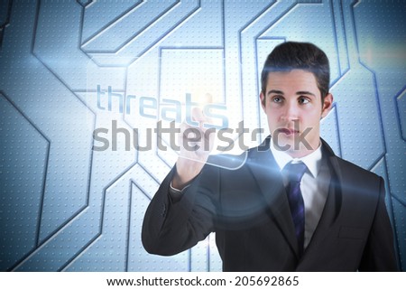 Businessman pointing to word threats against circuit board on futuristic background