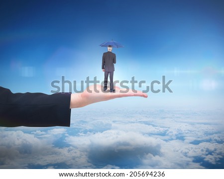 Businessman holding umbrella against blue sky over clouds at high altitude